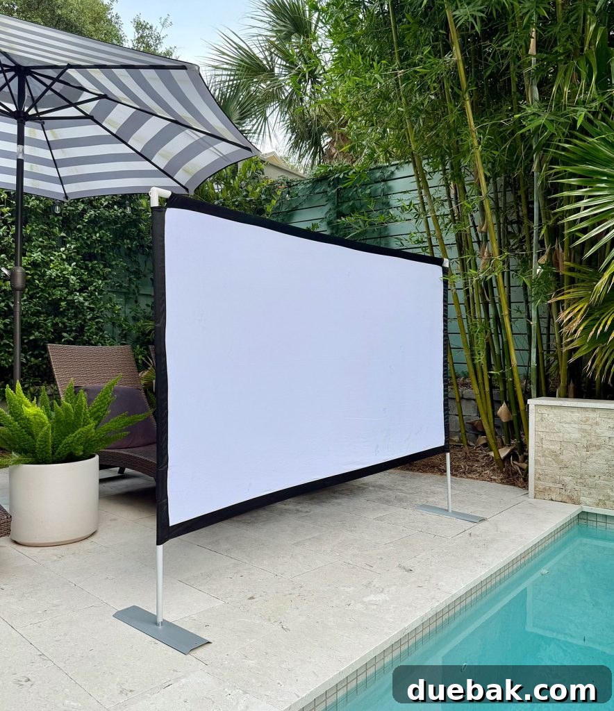 Collapsible Screen Set Up By Pool For Outdoor Movie Night - A large white projector screen positioned next to a swimming pool for evening entertainment.