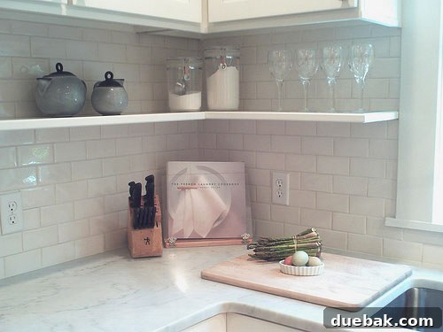Crisp White Kitchen: Subway Tile Delivers Timeless Style 5 An overview of the redesigned kitchen layout after renovation, showing improved workflow, modern stainless steel appliances, and custom lighting fixtures.