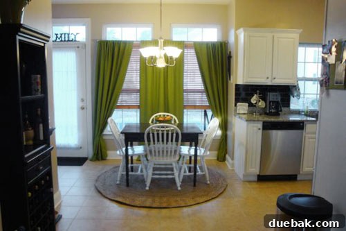 kitchen breakfast nook with rich green curtains on two windows