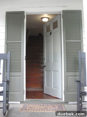 Stunning Richmond Transformation 15 Welcoming front entrance of the historic home, featuring classic shutters flanking the door and two inviting rocking chairs on the porch, enhancing its curb appeal.