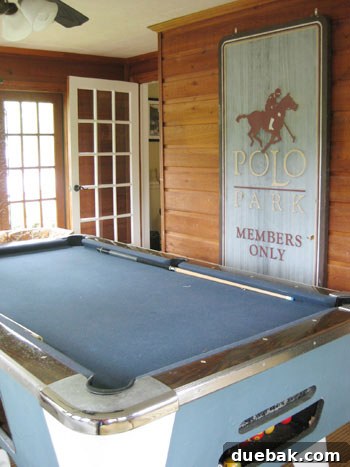 Stunning Richmond Transformation 3 Stylish game room featuring a navy pool table, vintage Ralph Lauren sign, and unique lighting, embodying a blend of recreation and classic American decor.
