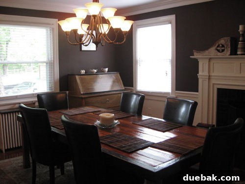 Stunning Richmond Transformation 6 Stunning dining room with dramatic deep slate walls, elegant chair rail, a refinished fireplace, and a large custom-made reclaimed wood dining table.