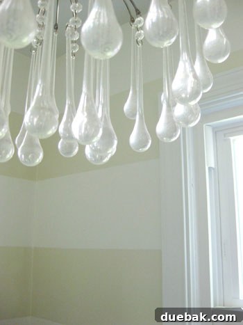 Close-up of a crystal chandelier against newly painted wall stripes