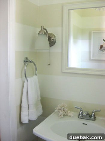Detailed shot showing how to paint bathroom stripes around wall sconces