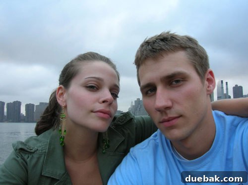 A couple poses playfully against the New York City skyline before their big move.