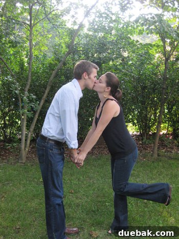 Another anniversary picture of a happy couple in their backyard, with hedges in the background, capturing a tender moment in their cherished wedding venue.
