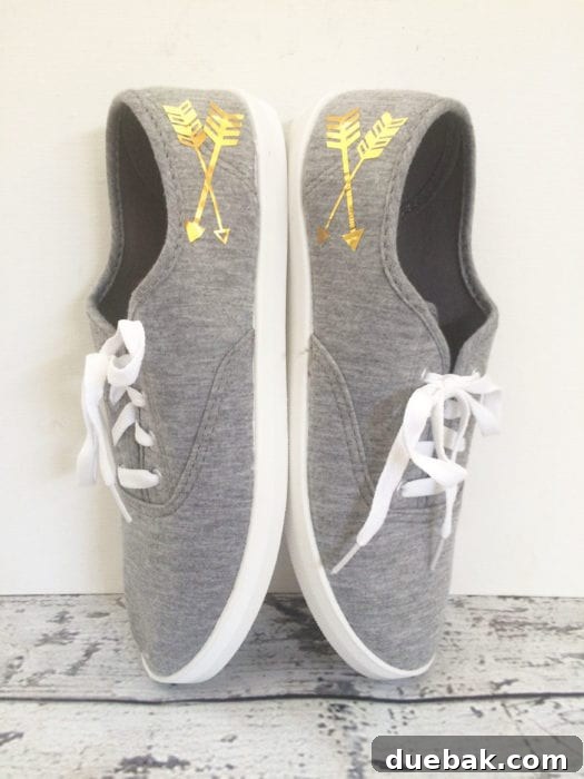 Grey sneakers with gold metallic arrow designs, showcasing a simple yet stylish personalization