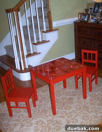 DIY Kids' Furniture: Vibrant Paint Makeover 4 The fully customized red IKEA kids table with a high-gloss finish, featuring a colorful, whimsical alphabet design, paired with matching chairs.