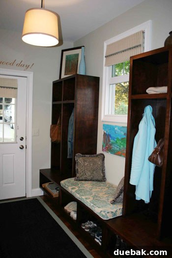 After image of a bright entryway featuring white walls, custom DIY lockers with a bench, a patterned rug, and a quote above the door.