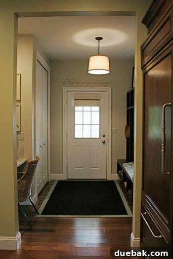 Detailed view of the mudroom desk area with a magnetic chalkboard wall displaying child's art, and the custom bench cushion.