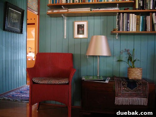 Close-up of the stylish teal wall in Trish's transformed living room, highlighting the playful mix of colors and textures, including decorative elements.