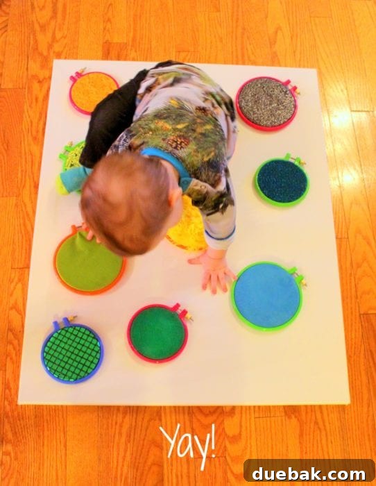 Finished DIY sensory board with various textured hoops, ready for a baby or toddler to explore