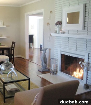 Current photo of the living room fireplace, now painted a lighter color, showcasing modern renovation.