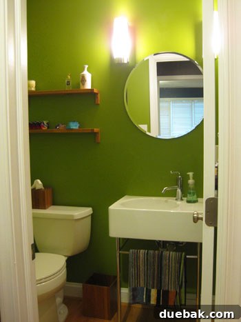 Vibrant green bathroom featuring modern white fixtures, a large mirror, and a cheerful color palette that invigorates the space
