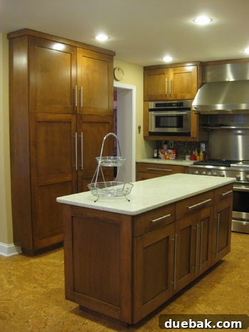 Spacious and organized kitchen pantry featuring elegant floor-to-ceiling storage doors and a functional central island, designed for efficiency and aesthetics