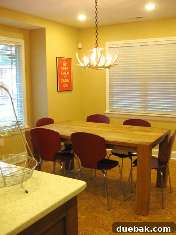 Elegant dining area highlighted by a distinctive white ceramic antler chandelier, a rustic modern wood dining table, and durable self-healing cork floors