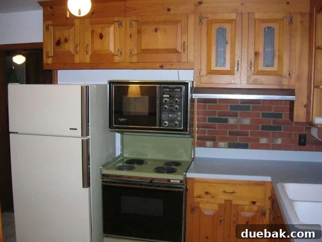 Original 1970s kitchen before any renovations, featuring outdated design elements, dark wood tones, and a closed-off layout.