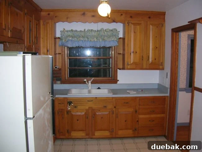 Another view of the original 1970s kitchen, highlighting its dated aesthetic, inefficient appliances, and lack of natural light.