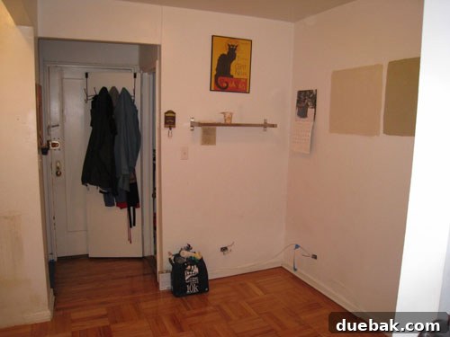 Before photo of the empty L-shaped wall in the NYC apartment, highlighting its potential for kitchen expansion
