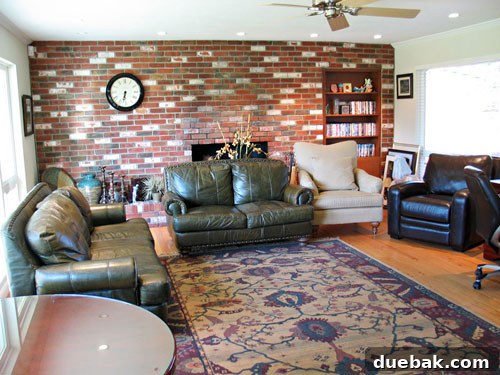 Before shot of Amy's living room with dated brick fireplace and light walls