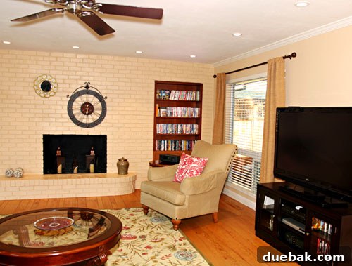 Cozy after shot of Amy's living room, showcasing new wall colors, patterned rug, and repurposed furniture
