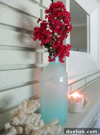 Living room mantel with blue vase and pink crape myrtle branch