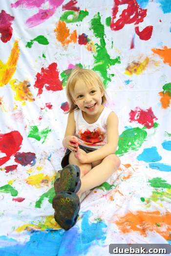 Clara sitting calmly for photos, with paint visible on her clothes