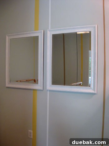 Nursery wall with two large mirrors and six hooks underneath, creating a modern display and storage area.