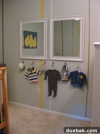 Close-up of three empty foldable hooks mounted on the nursery wall, showcasing their clean design.