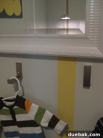 A foldable hook fully collapsed and neatly snapped into place against the wall, showcasing its discreet profile.