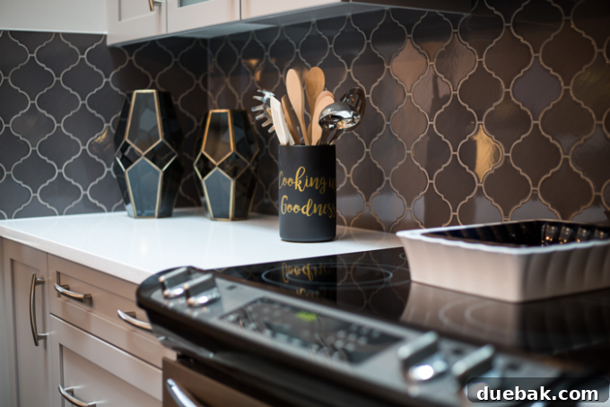 Modern kitchen with dark patterned tiles and light grey cabinets