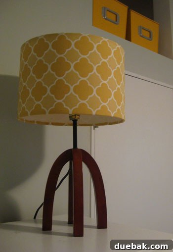 DIY Fabric Lamp Shade Makeover 5 Customized table lamp with a new yellow fabric shade on top of an armoire.
