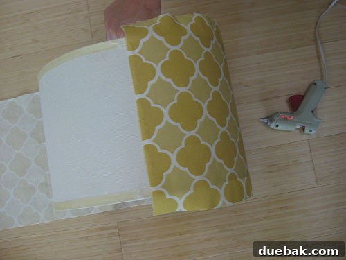 DIY Fabric Lamp Shade Makeover 9 One end of the fabric being glued onto the lampshade.