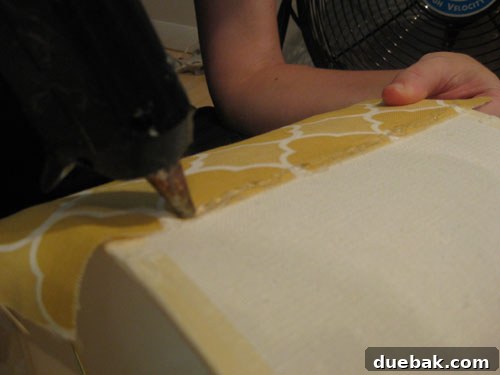 DIY Fabric Lamp Shade Makeover 10 Applying a bead of glue on the finished edge of the fabric, ready for wrapping.