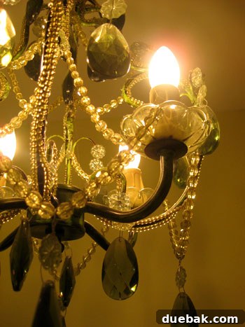 A green chandelier hanging in Olivia's renovated bathroom, adding a luxurious touch