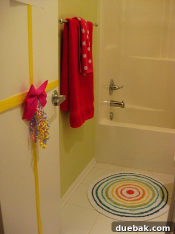 Close-up of the green painted wall with hot pink accents in Olivia's bathroom