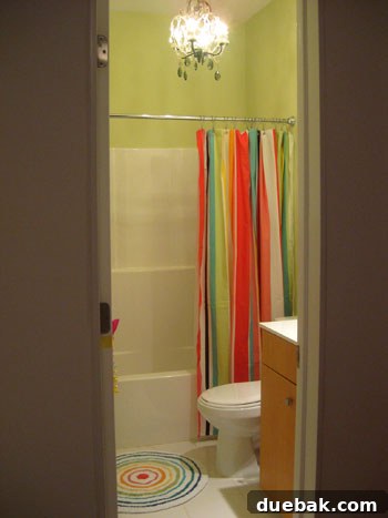 Olivia's newly made over bathroom, featuring green walls and vibrant decor