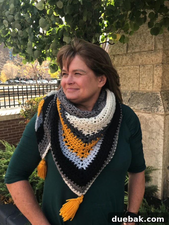 Statement Crochet Pointed Shawl 4 Stylish oversized crochet triangle scarf with a colorful striped pattern, perfect for chilly weather
