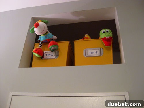 Top of the armoire with a lamp, baby monitor, and framed photos