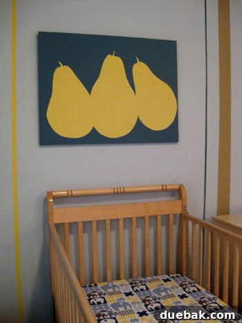 Crib area in the nursery with pear artwork above