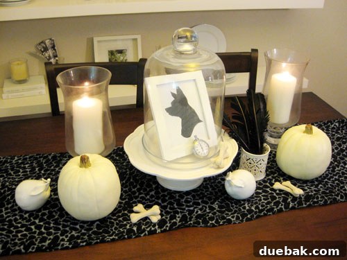 Halloween dining table with dog bone treats as decor and white pumpkins