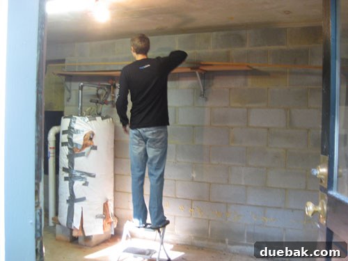 Old, sagging wooden shelves on basement wall before removal