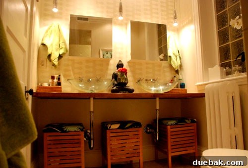 Modern bathroom after renovation with light tiles and wallpaper