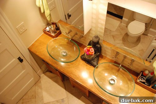 Stylish bathroom vanity area with custom storage and elegant wallpaper