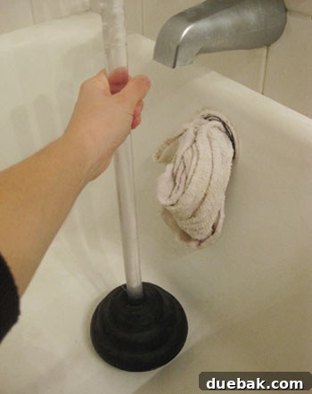 unclogging bathtub drain with plunger