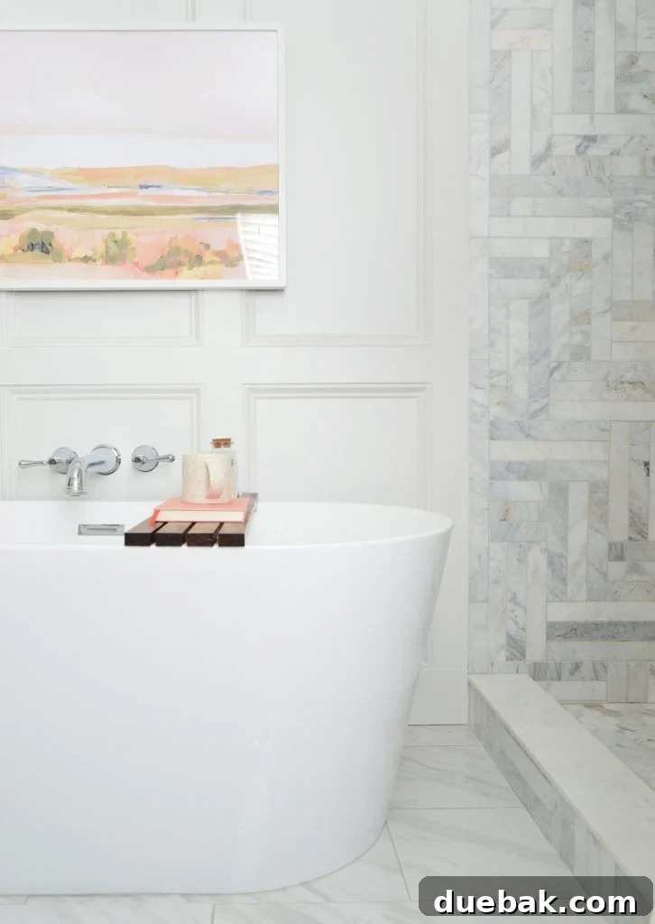 Freestanding tub side view in modern bathroom with marble shower