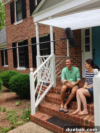 Man holding a sleeping dog on his porch during an interview
