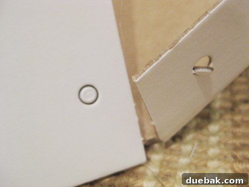 Hand punching out a hole in IKEA Kassett box cardboard