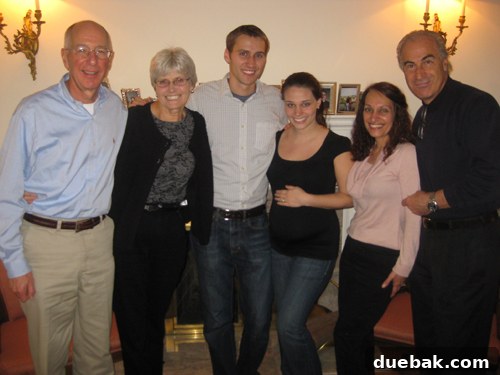 John and Sherry Petersik smiling with family after the pregnancy reveal, a joyful candid moment.