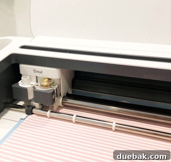 Build Your Own Adventure Car Play Mat with Cricut Maker 3 Close-up of Cricut Maker machine cutting fabric with a rotary blade for a DIY car play mat.